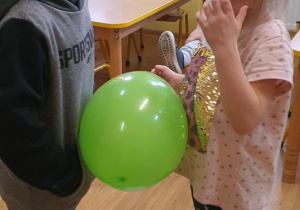 Tomek i Idalia tańczą z balonem.